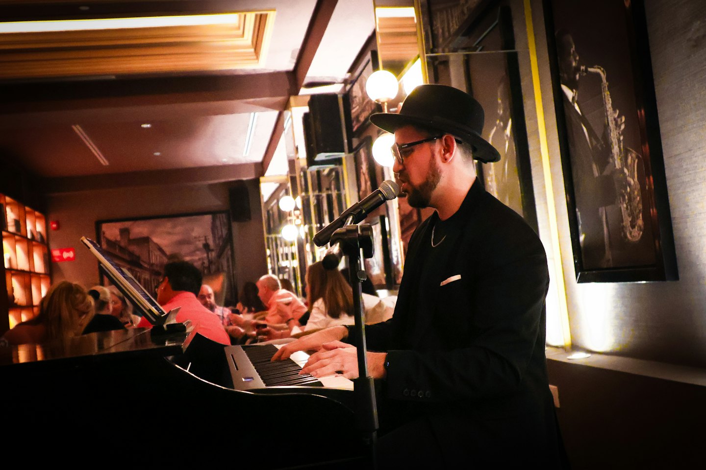 Musicista che suona un pianoforte digitale e canta al microfono.