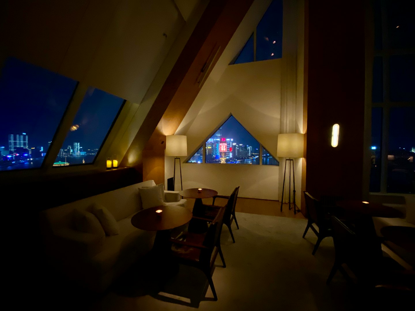 Lussuosa sala d'attesa vuota con vista su uno skyline cittadino illuminato.