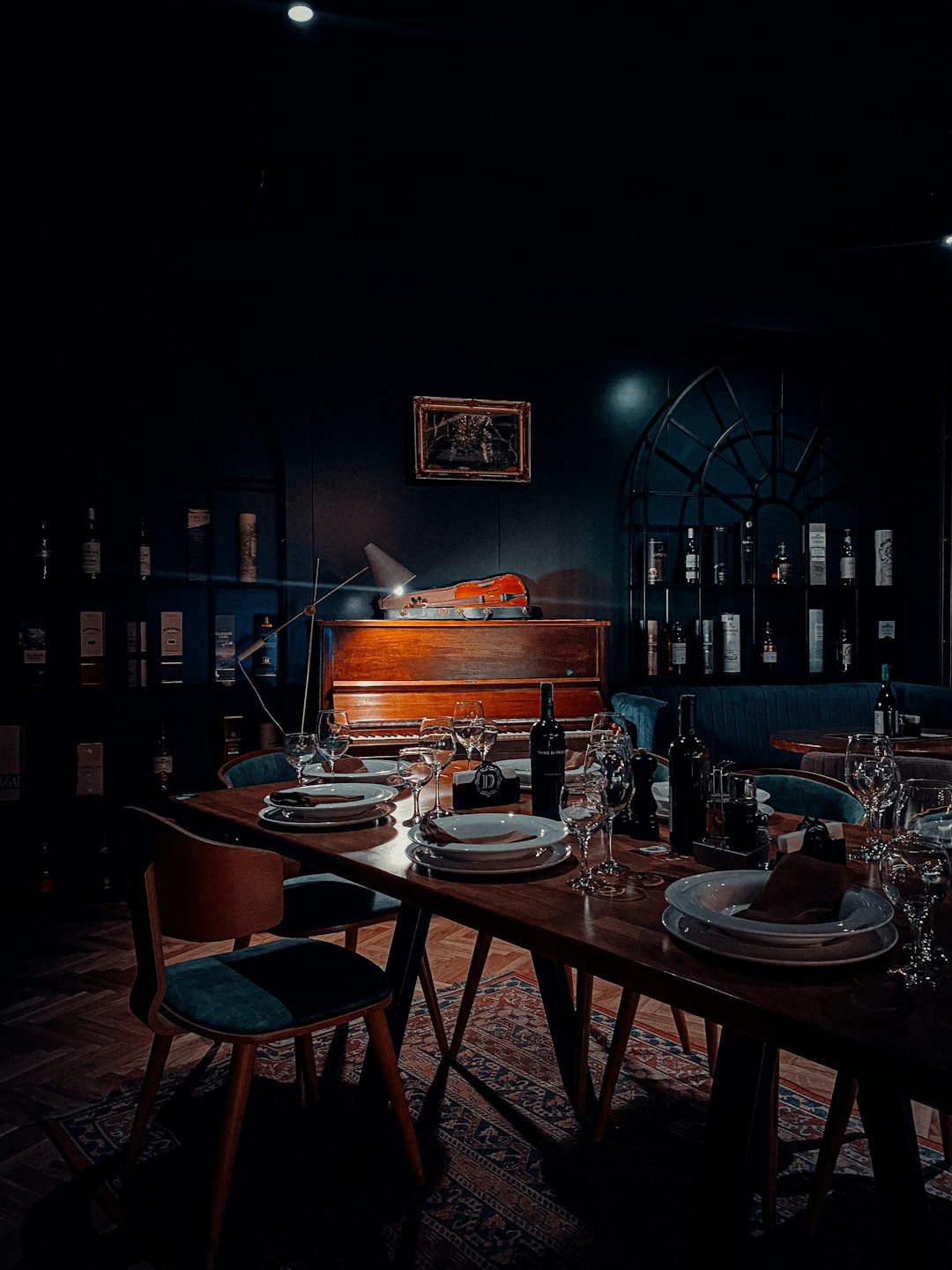 Tavola apparecchiata con piatti e vino in un ristorante.