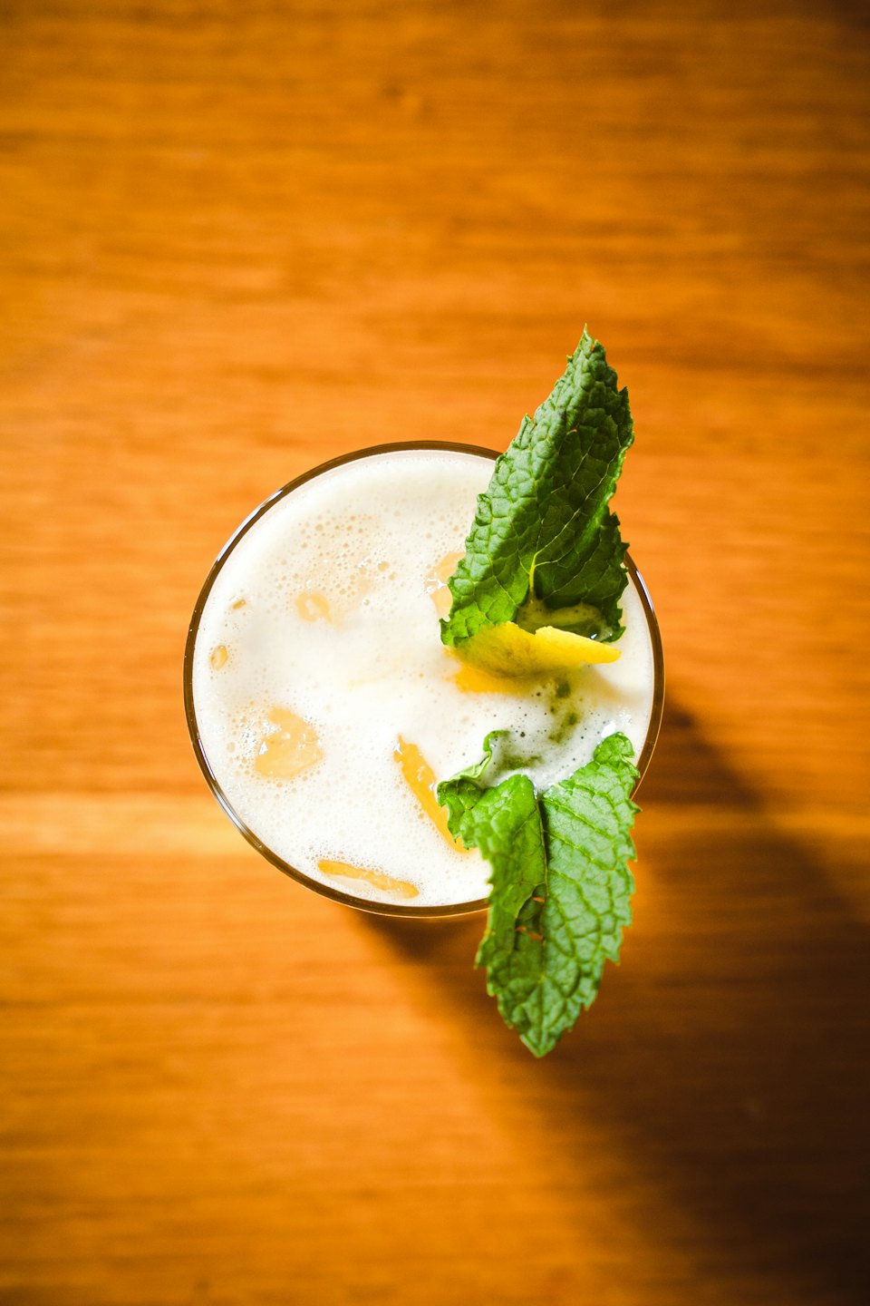Un cocktail rinfrescante con menta e agrumi su un tavolo di legno.